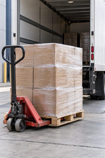 Illustrative photo of a packed pallet beside a delivery truck.