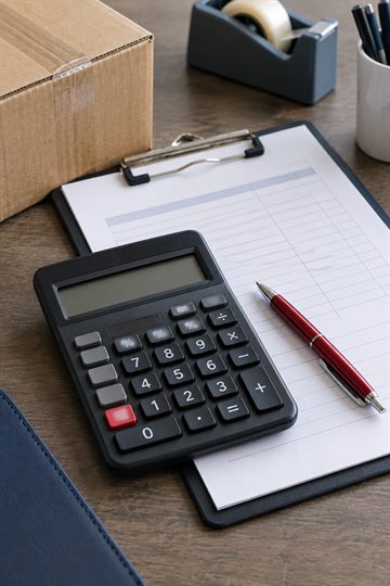 Illustrative photo of freight paperwork and a calculator.